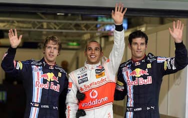 McLaren Mercedes driver Lewis Hamilton of Britain, center, who took pole position, Red Bull driver Sebastian Vettel of Germany, left, placed second on the grid, Red Bull driver Mark Webber of Australia, right, third, react after a qualifying session for Sunday's Abu Dhabi Grand Prix at the Yas Marina racetrack, in Abu Dhabi, United Arab Emirates, Saturday, Oct. 31, 2009. The Emirates Formula One Grand Prix will take place on Sunday, Nov. 1. (AP Photo/Luca Bruno)