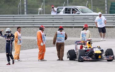 epa02180050 German Sebastian Vettel (L) of Red Bull walks away after being forced to retire after a crash with his teammate Australian Mark Webber at Istanbul Park circuit in Istanbul, Turkey on 30 May 2010. Lewis Hamilton won the Turkish Formula One Grand Prix ahead of McLaren team-mate Jenson Button. Mark Webber came third on a Red Bull to retain the world championship lead after losing the race lead in a collision with team-mate Sebastian Vettel.  EPA/STR