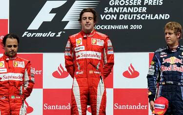 Ferrari Formula One driver Fernando Alonso of Spain, center, closes his eyes during the national anthem after winning the German Formula One Grand Prix in Hockenheim, Germany,  Sunday, July 25, 2010. Ferrari driver Felipe Massa of Brazil, left, finished second, German Red Bull driver Sebastian Vettel, right, finished third. (AP Photo/Martin Meissner)