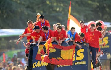 epa02246524 (L-R) Spanish national soccer team players Sergio Ramos, Pepe Reina, Sergio Busquets, Alvaro Arbeloa, Fernando Llorente, David Villa, Jes?s Navas, Juan Mata and Iker Casillas cheer on top of a a convertible bus as they tour downtown Madrid, central Spain, on 12 July 2010. Spain won the FIFA 2010 World Cup final 1-0 against Netherlands.  EPA/ZIPI