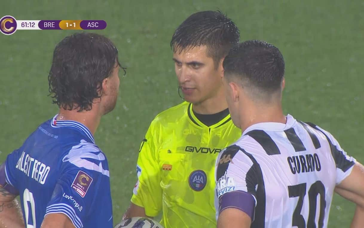 Arbitro e giocatori durante la sospensione della gara